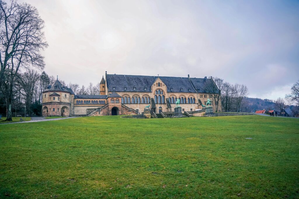 Beautiful view of the Imperial Palace of Goslar, Germany, surrounded by lush greenery and winter sky.