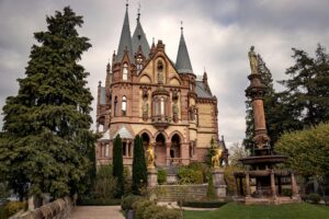 Explore the stunning architecture of Schloss Drachenburg in Königswinter, Germany, surrounded by gardens and sculptures.