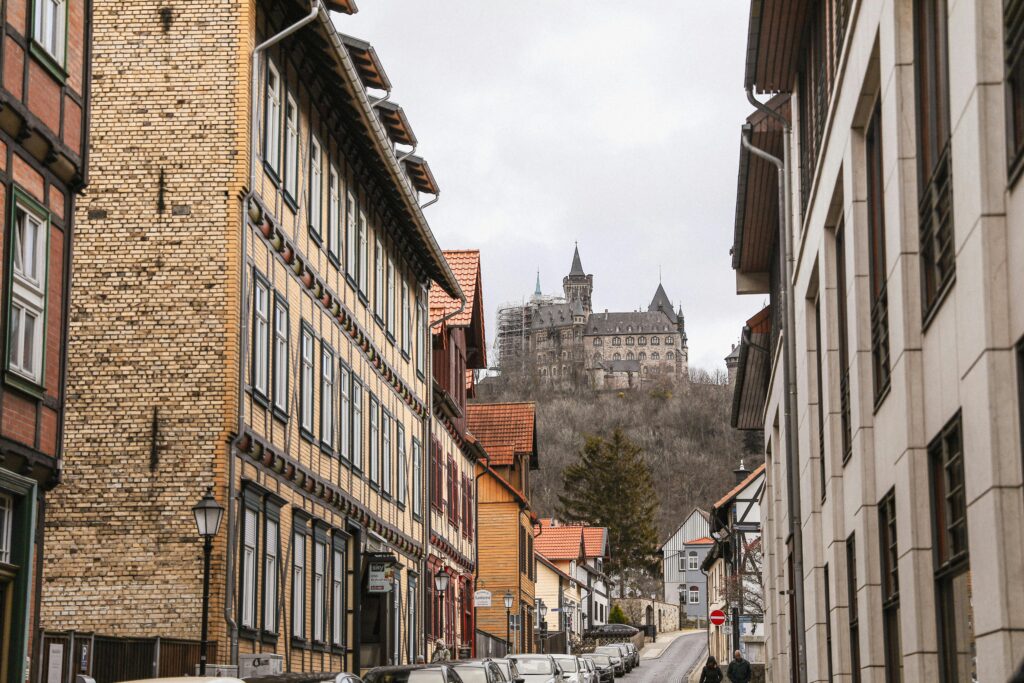 Charming medieval street in Wernigerode, Germany with Wernigerode Castle in the background.