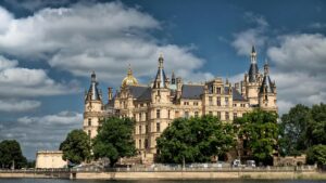 Majestic Schwerin Castle set against a backdrop of greenery and clouds in Schwerin, Germany.